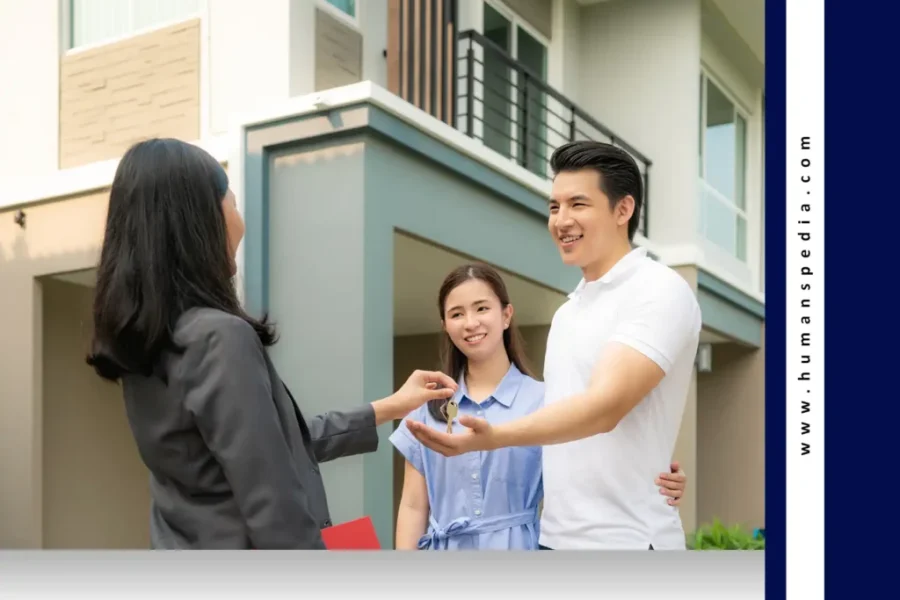 Three people standing in front of a modern house, with one handing over keys to another — representing a real estate transaction and the excitement of owning Bali property